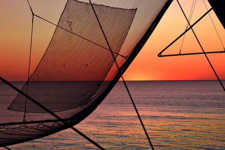 zonsondergang door het net van de carrelet