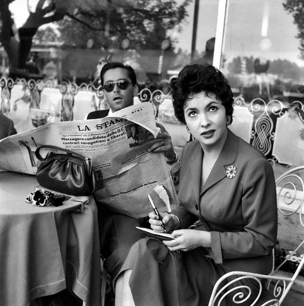 Gina Lollobrigida aan tafel in een bar met haar man