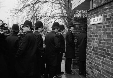 Cola de policías para el aseo de caballeros